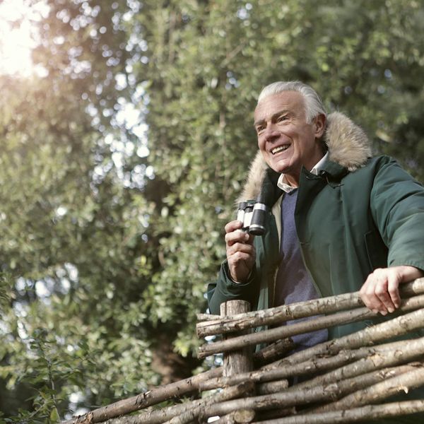 Smiling person stretching outdoors, looking refreshed and happy.